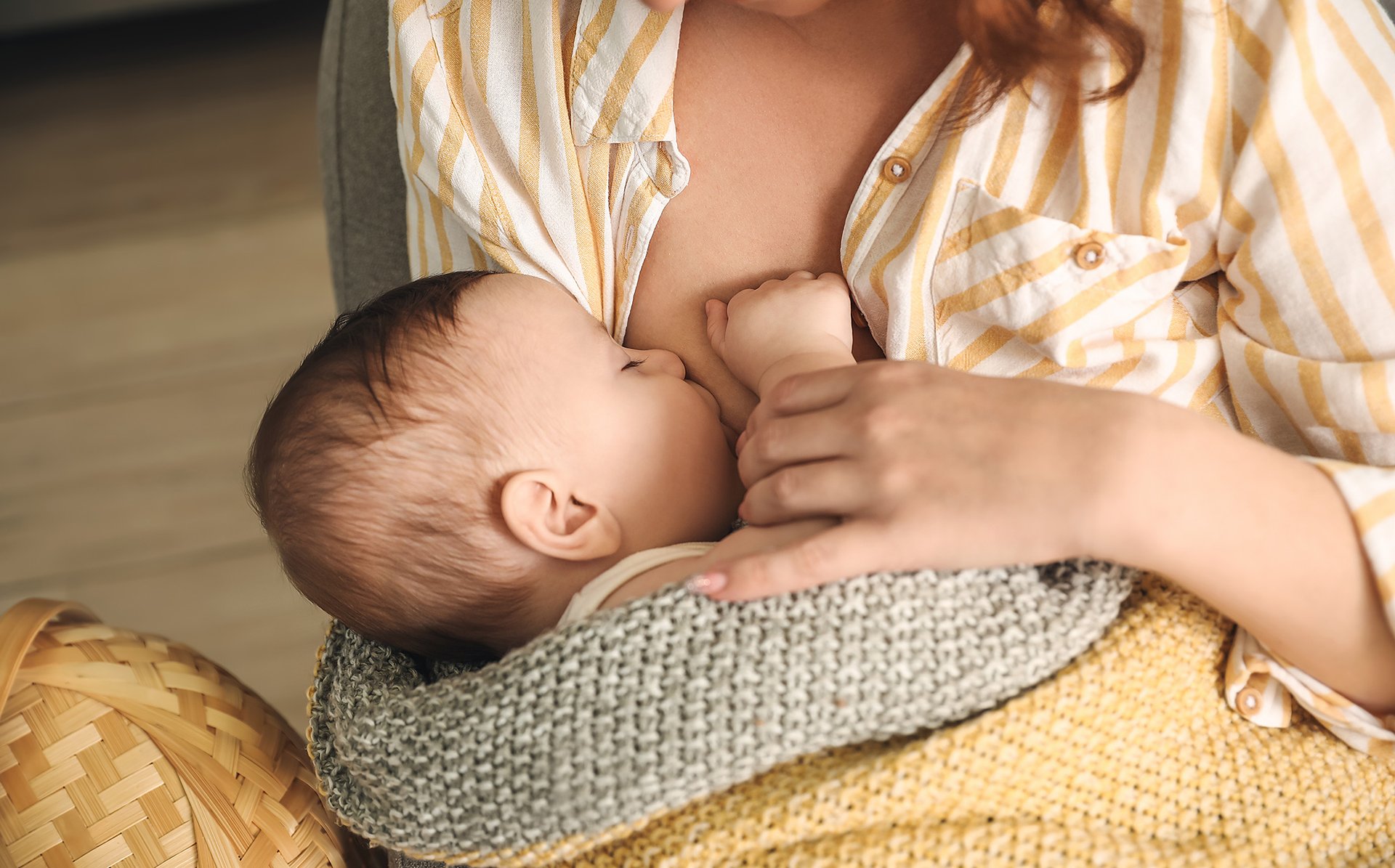 Mama karmi piersia dziecko owiniete w koc