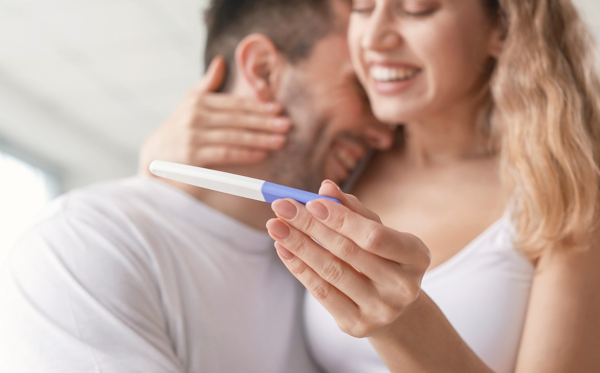 Mama tuli się do partnera i trzyma test ciazowy