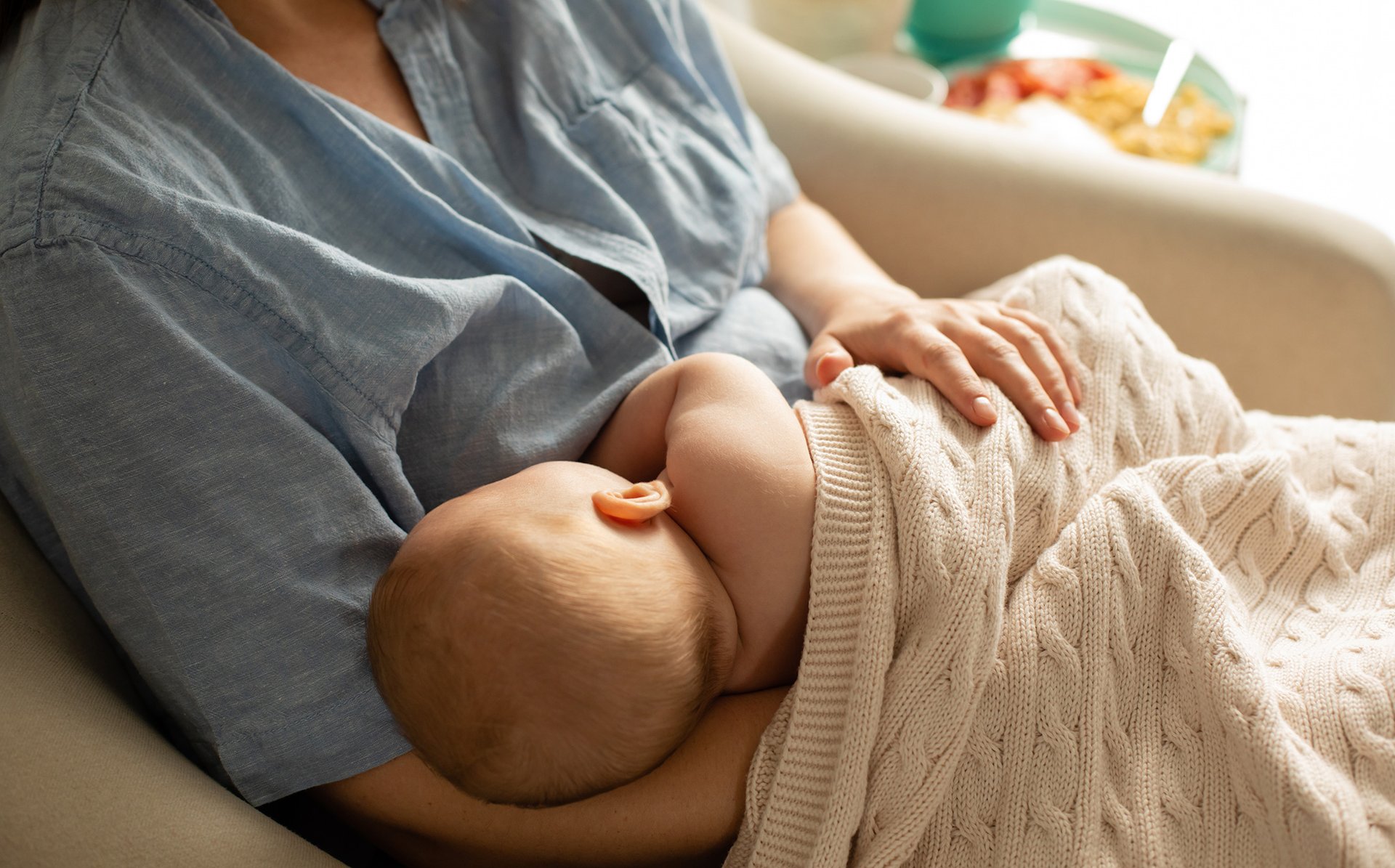 Mama karmi piersia dziecko przykryte kocykiem