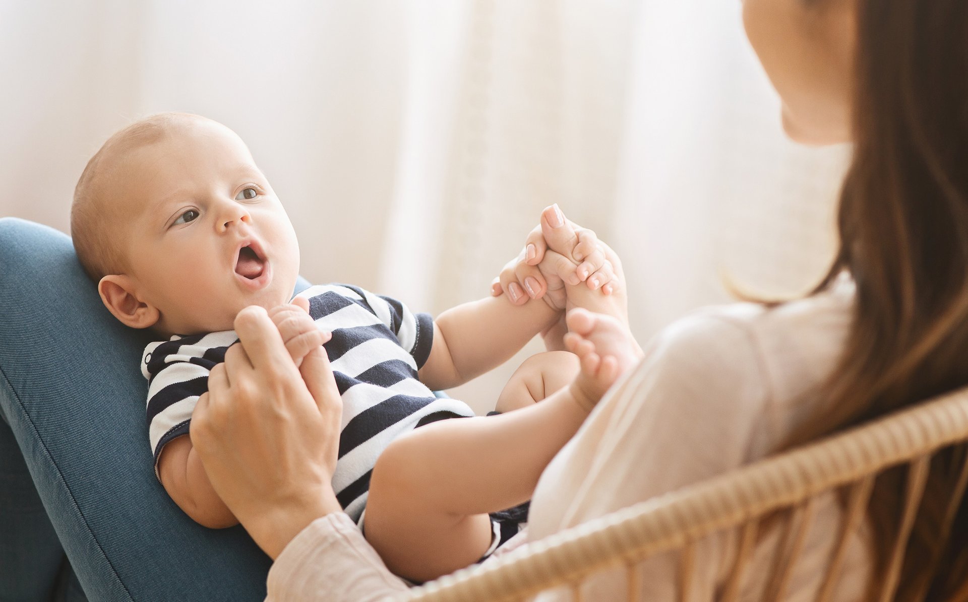 Mama rozmawia z noworodkiem lezacym na kolanach