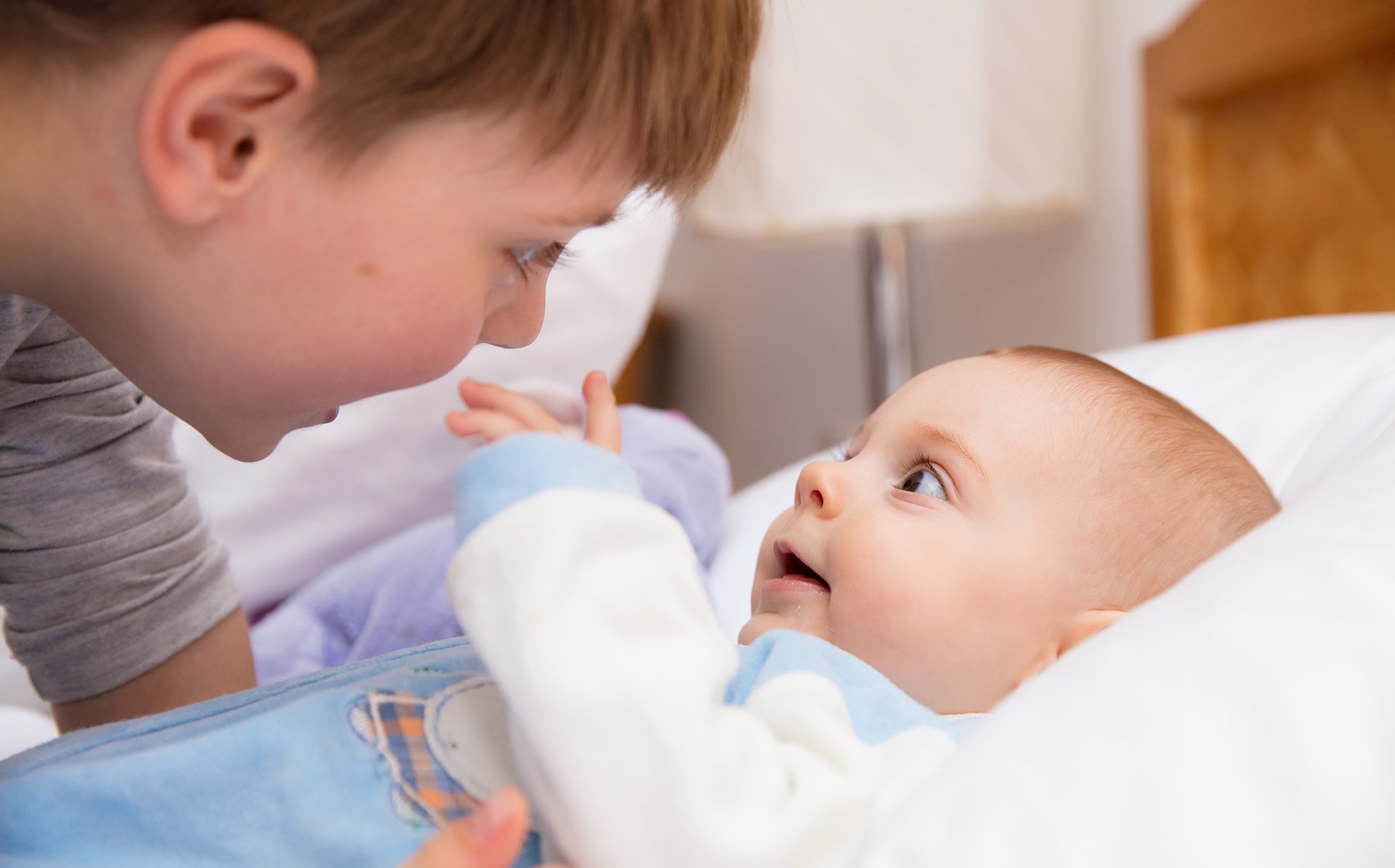 Chlopiec usmiecha sie do lezacego niemowlaka