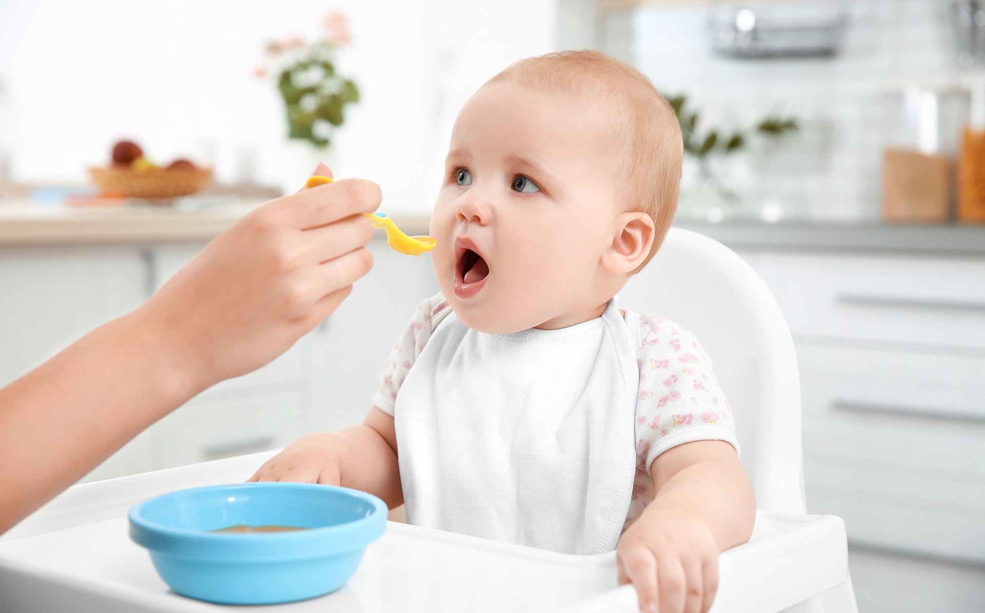 Mama karmi dziecko jedzeniem za pomoca lyzeczki